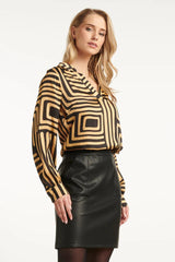 https://cdn.shopify.com/s/files/1/1007/1746/1833/files/imgi_54_25579-Zwart-en-Goud-Grafische-geprint-Top-met-Kraag-Black-Camel-3.jpg?v=1775523932